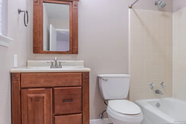 a bathroom with a sink vanity mirror and toilet
