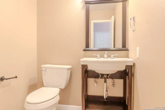 a bathroom with a toilet a sink and a mirror