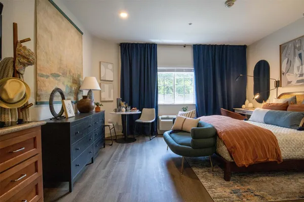 a bedroom with furniture and a large window