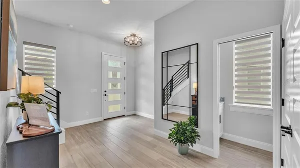 a view of a hallway with wooden floor and a window