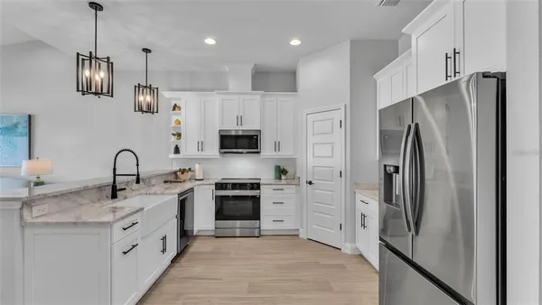 a kitchen with stainless steel appliances granite countertop a refrigerator and cabinets