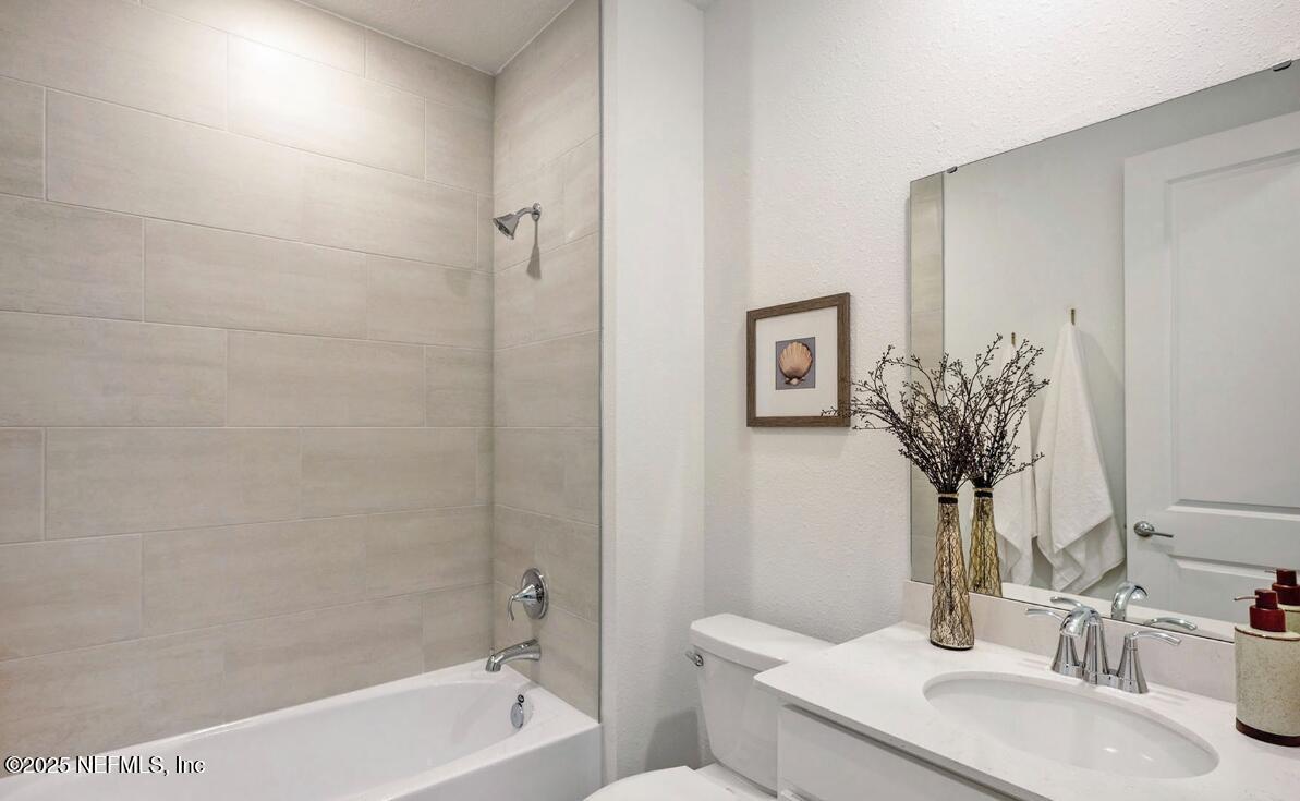 75705 Walking Path Lane Yulee, FL 32097 - Photo 24 of 37 a bathroom with a granite countertop sink a toilet and shower