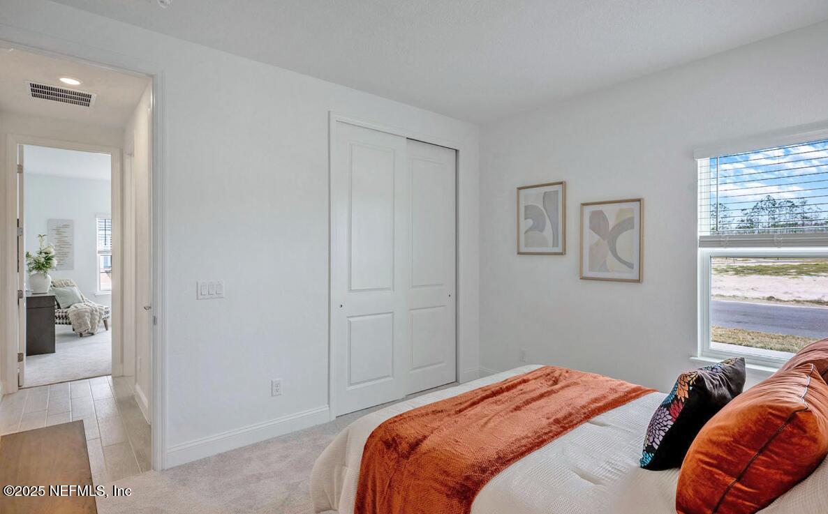 75705 Walking Path Lane Yulee, FL 32097 - Photo 26 of 37 a bedroom with a bed and a window