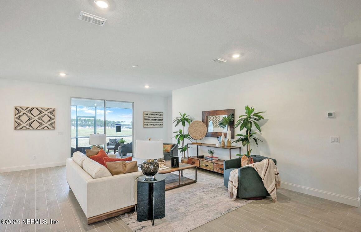 75705 Walking Path Lane Yulee, FL 32097 - Photo 30 of 37 a living room with furniture and a potted plant