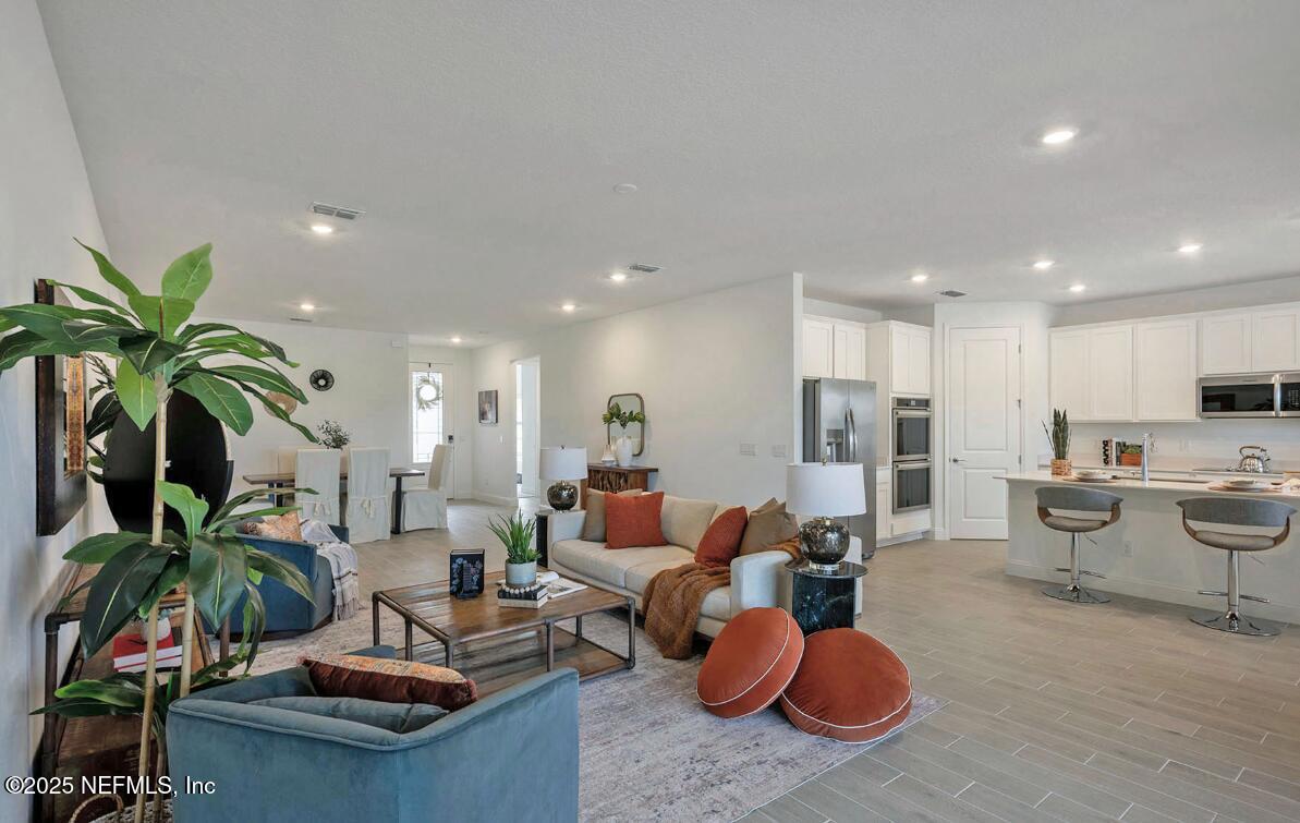 75705 Walking Path Lane Yulee, FL 32097 - Photo 31 of 37 a living room with furniture kitchen view and a potted plant