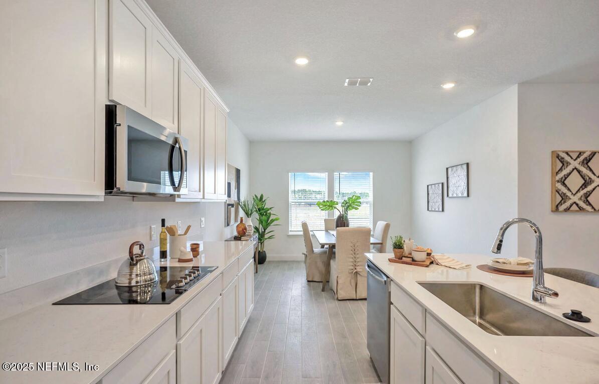 75705 Walking Path Lane Yulee, FL 32097 - Photo 35 of 37 a kitchen that has a sink and a stove in it