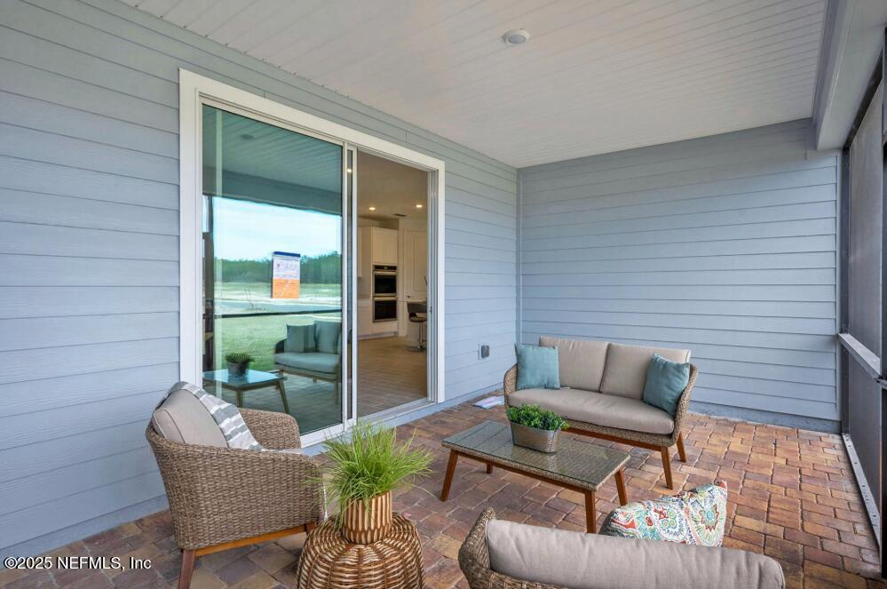 75705 Walking Path Lane Yulee, FL 32097 - Photo 36 of 37 a balcony with furniture and a potted plant