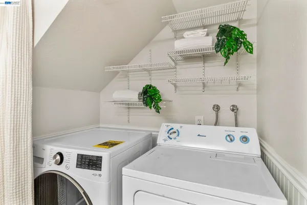 a view of washer and dryer with kitchen in the background