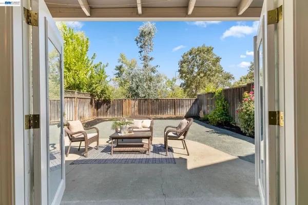 a view of a patio with table and chairs potted plants with wooden fence