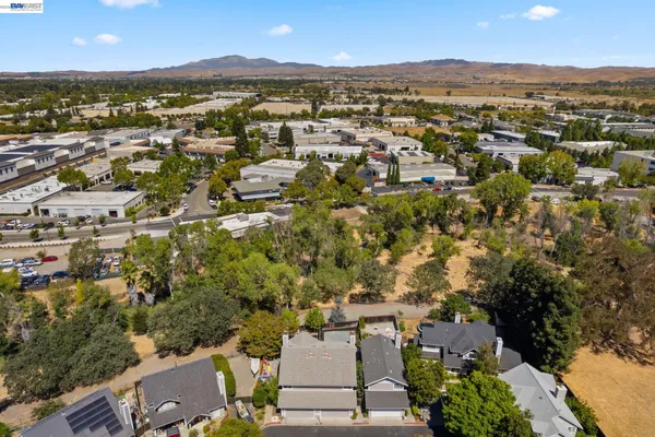 an aerial view of residential houses with outdoor space and trees