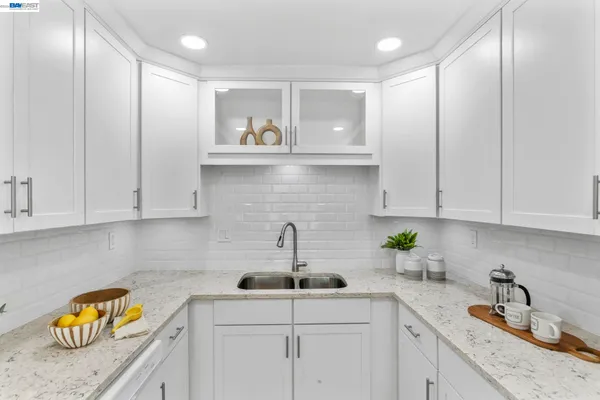 a kitchen with stainless steel appliances granite countertop a sink a stove cabinets and wooden floor