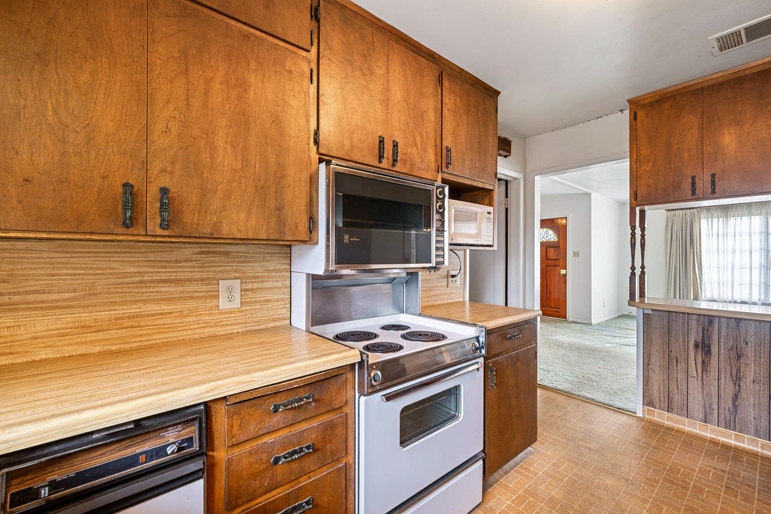 183 Harrison Street Coalinga, CA 93210 - Photo 17 of 45 a kitchen with stainless steel appliances a stove a microwave and cabinets