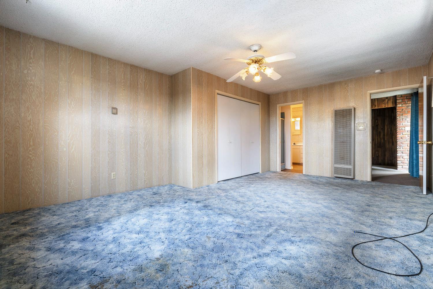 183 Harrison Street Coalinga, CA 93210 - Photo 24 of 45 an empty room with chandelier fan and windows