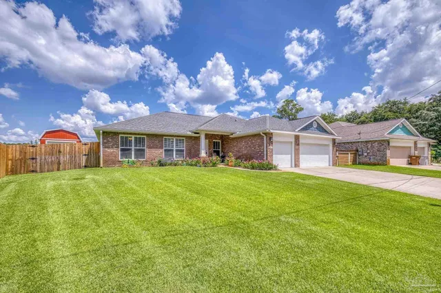 a front view of a house with yard and green space