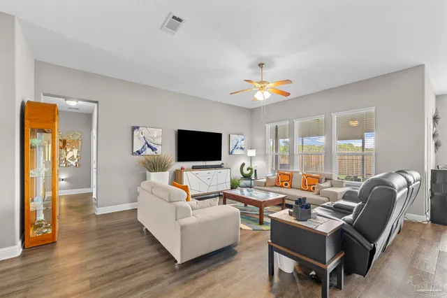 a living room with furniture and wooden floor