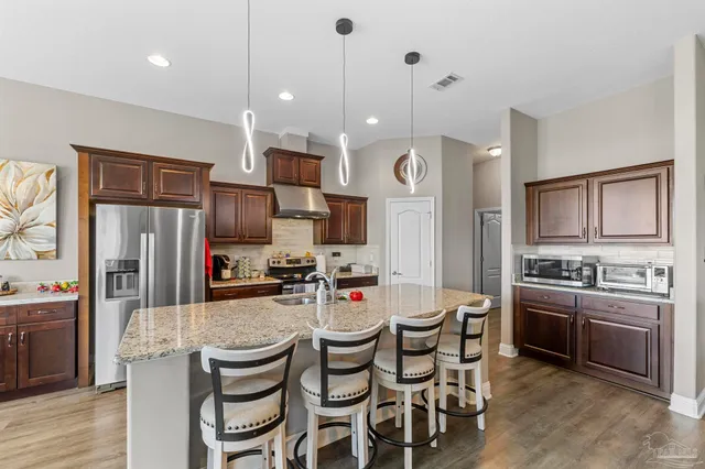 a kitchen with sink stove top oven and refrigerator