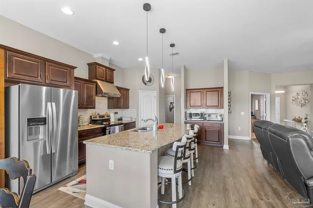 a kitchen with stainless steel appliances granite countertop a sink stove and refrigerator