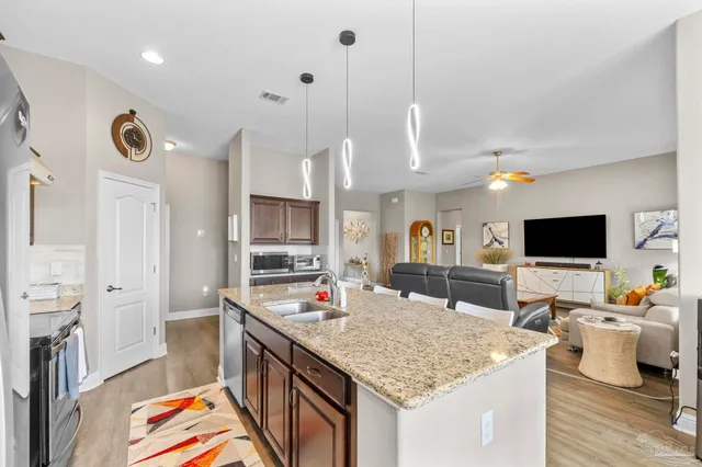 a kitchen with lots of counter top space a sink appliances and cabinets