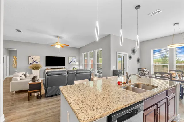 a dining room with furniture a chandelier and wooden floor