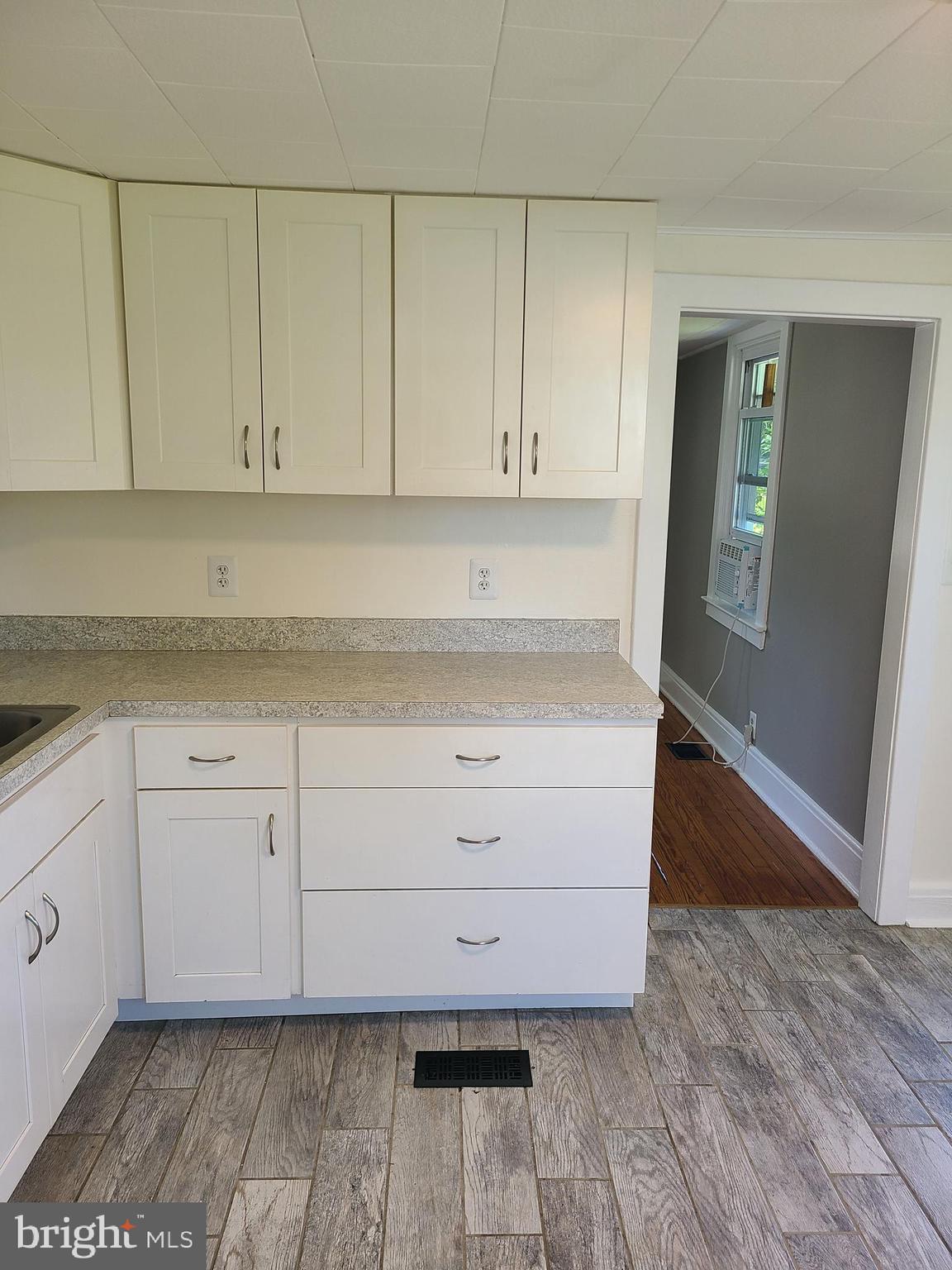 1700 Goodview Road Parkville, MD 21234 - Photo 14 of 50 a kitchen with granite countertop white cabinets and a wooden floor