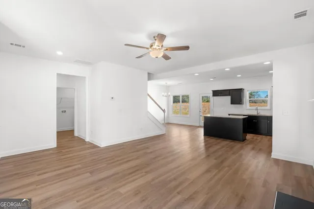 a view of a kitchen with a sink a refrigerator and a stove top oven