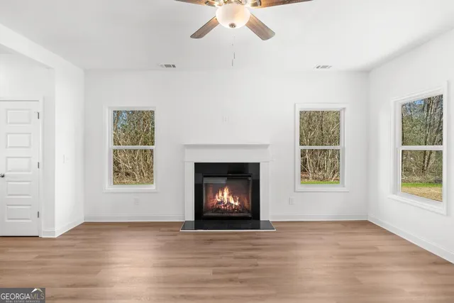 an empty room with windows and fireplace