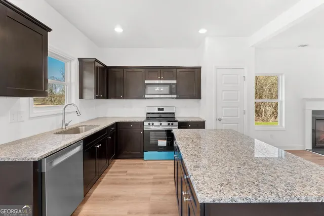 a kitchen with stainless steel appliances granite countertop a sink stove and refrigerator
