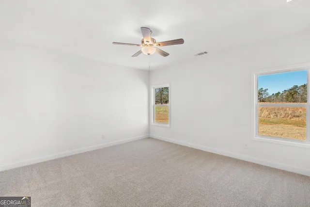 an empty room with a window and a fan