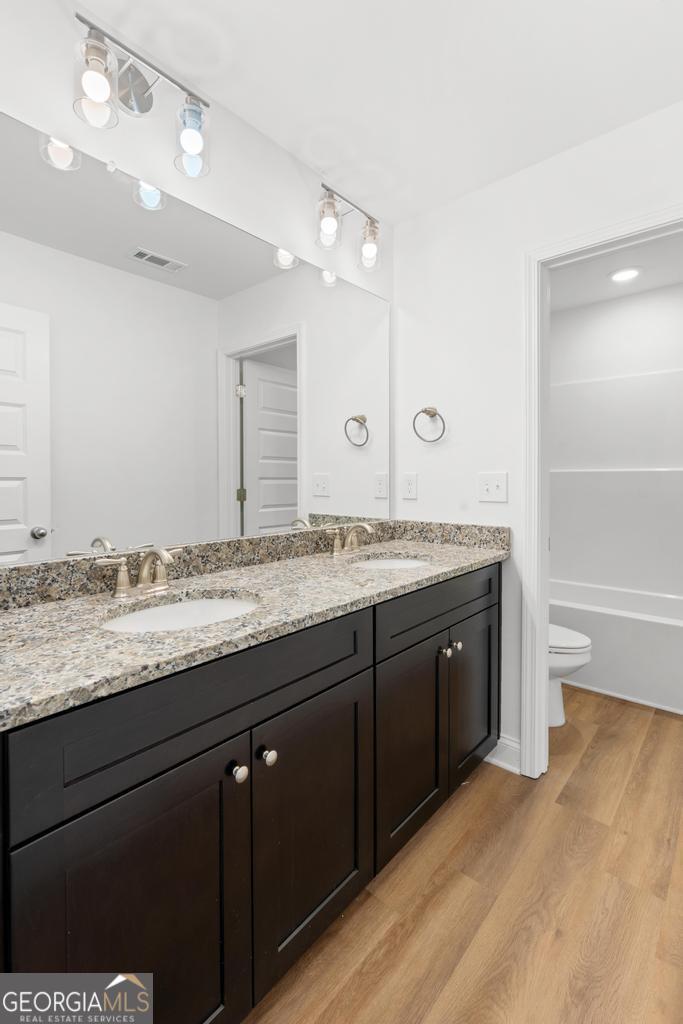59 Oak Road Locust Grove, GA 30248 - Photo 30 of 38 a bathroom with a granite countertop sink a large mirror and a bathtub