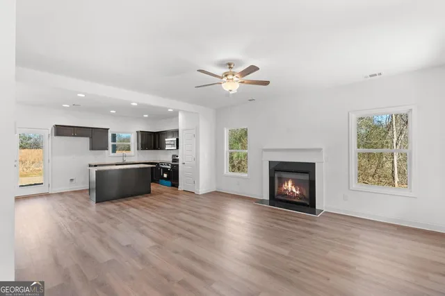 a view of a kitchen with a sink a fireplace and a large window