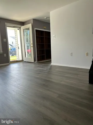 an empty room with wooden floor and window