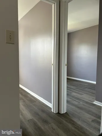 an empty room with wooden floor and entrance