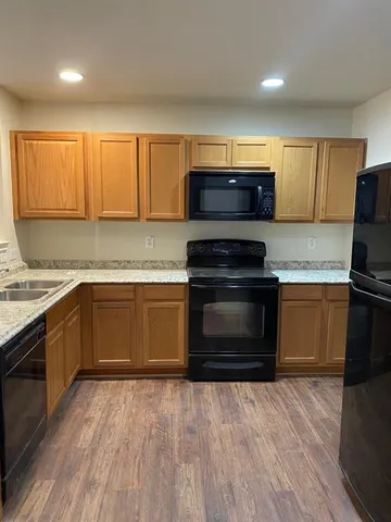 a kitchen with granite countertop a stove top oven and cabinets