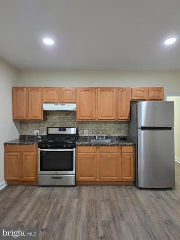 a kitchen with stainless steel appliances granite countertop a stove a refrigerator and a microwave