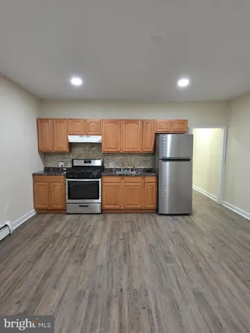 a kitchen with wooden floors and white stainless steel appliances