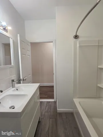 a bathroom with a tub sink and mirror
