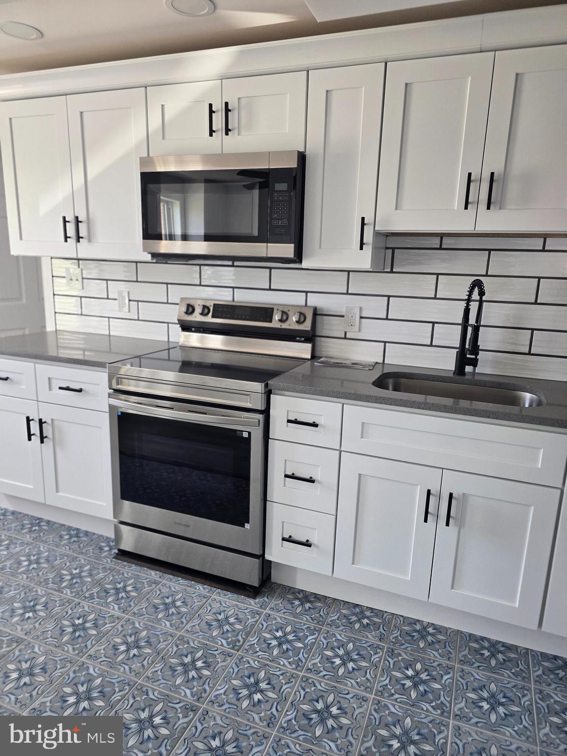 5925 Ridge Avenue, Unit 5 Philadelphia, PA 19128 - Photo 26 of 31 a kitchen with appliances a sink and cabinets