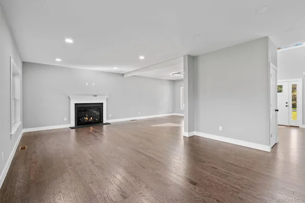 an empty room with wooden floor and fireplace