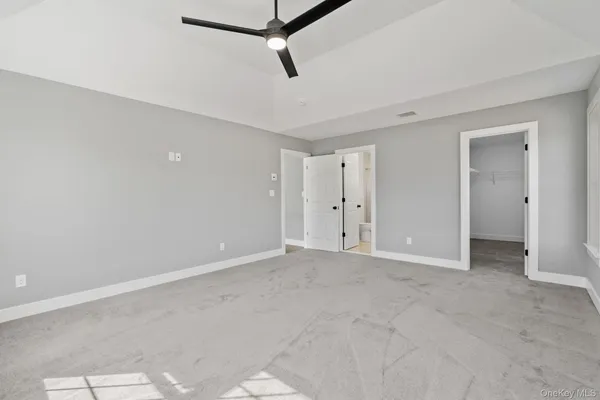 an empty room with windows and ceiling fan