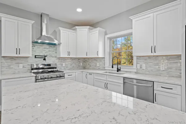 a kitchen with stainless steel appliances granite countertop a sink stove and cabinets