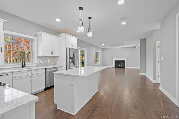 a large kitchen with kitchen island a large counter top space a sink stainless steel appliances and cabinets