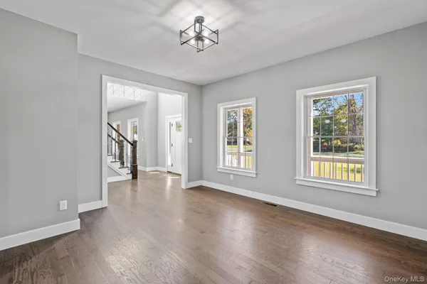 a hall with kitchen island a stove a wooden floor and a chandelier