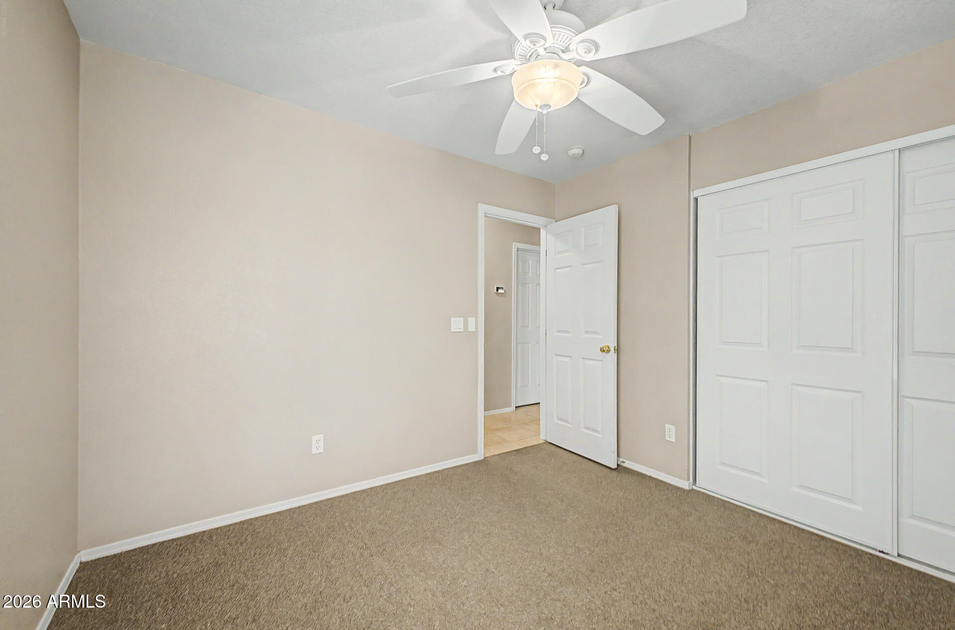 3489 South Bowman Road Apache Junction, AZ 85119 - Photo 21 of 24 an empty room with a chandelier fan and closet area