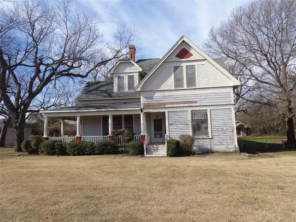 a view of a house with a yard and tree