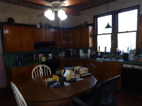 a kitchen with granite countertop a dining table chairs and a stove