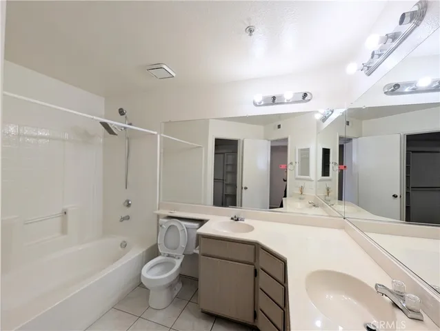 a bathroom with a double vanity sink toilet mirror and bathtub