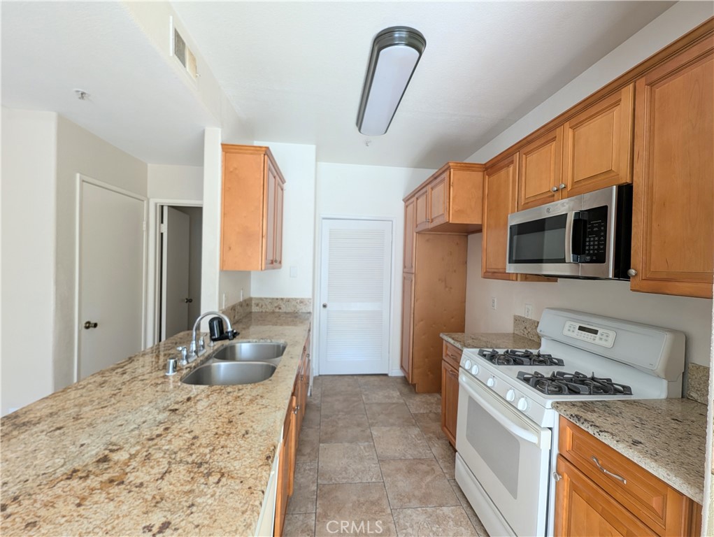 13133 Le Parc, Unit 1009 Chino Hills, CA 91709 - Photo 18 of 21 a kitchen with stainless steel appliances granite countertop a sink stove and refrigerator