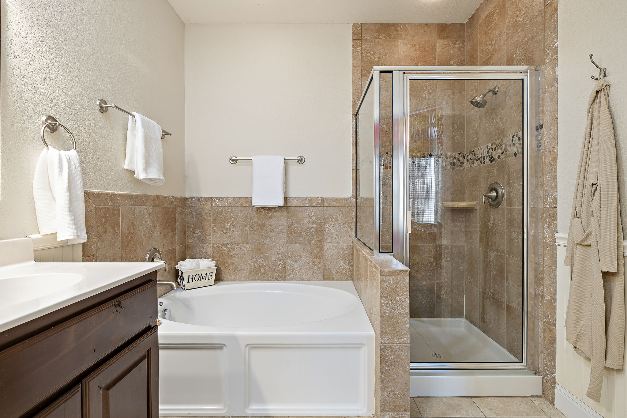 6708 Menchaca Road, Unit 10 Austin, TX 78745 - Photo 18 of 28 Bathroom featuring a glass-enclosed shower with tile surround, a built-in bathtub, and a dark wood-finish vanity with a white countertop and integrated sink