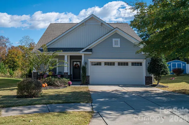 a front view of a house with a yard garage and outdoor seating