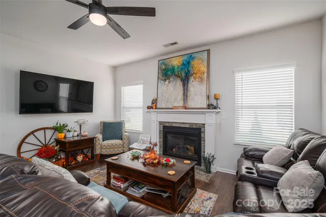a living room with furniture a fireplace and a flat screen tv
